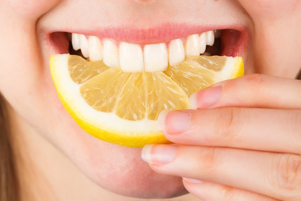 Woman eating lemon