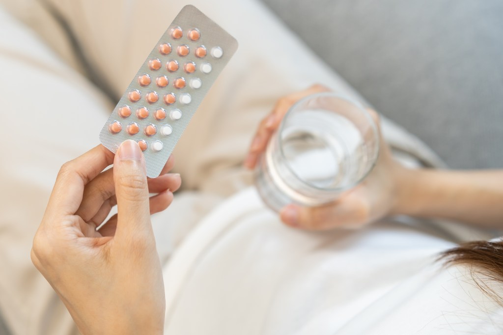 Woman holding birth control pills