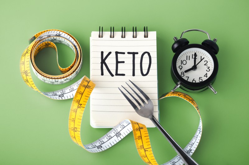 Keto on notebook, clock, and measuring tape