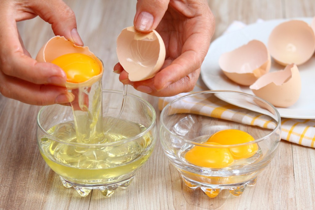 Woman separating egg yolks from whites