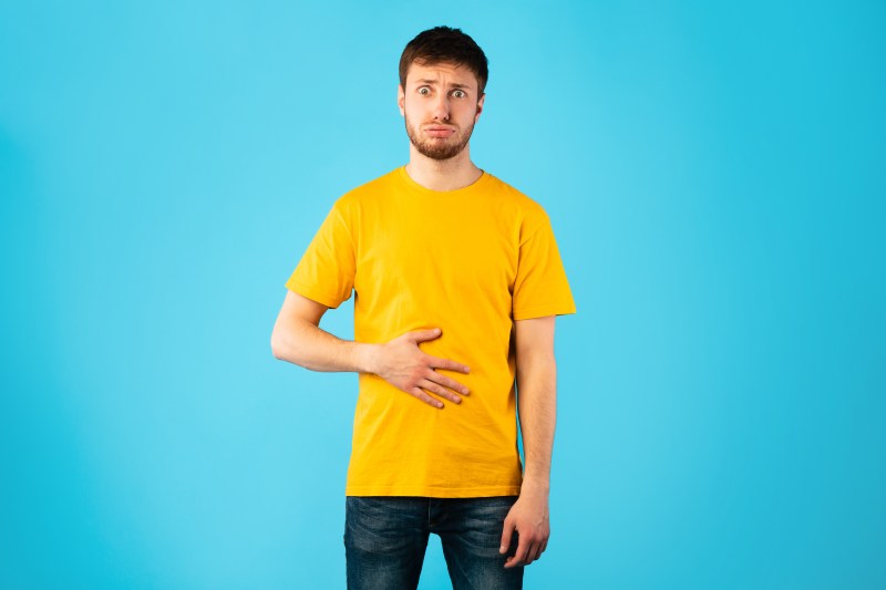Young man touching stomach